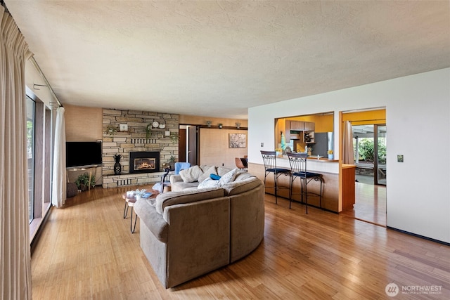 152 E Park Ln, Port Angeles, WA 98362 - living room with light wood-type flooring, a fireplace, and a textured ceiling