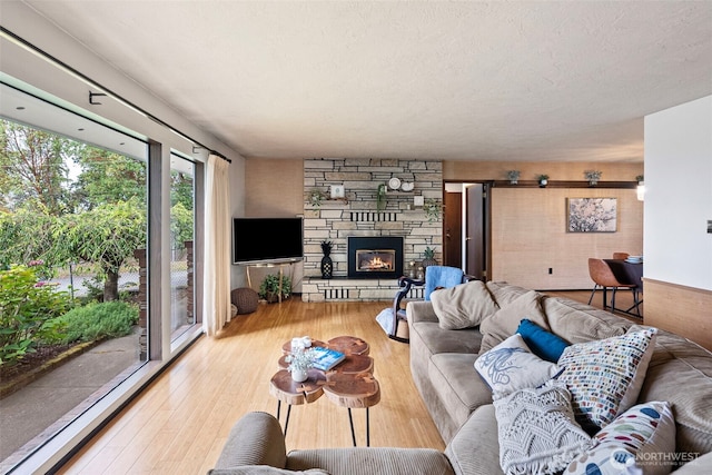 152 E Park Ln, Port Angeles, WA 98362 - living area with wood finished floors, a stone fireplace, and a textured ceiling