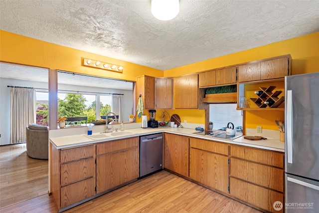 152 E Park Ln, Port Angeles, WA 98362 - kitchen featuring appliances with stainless steel finishes, a textured ceiling, light wood-style floors, light countertops, and brown cabinetry