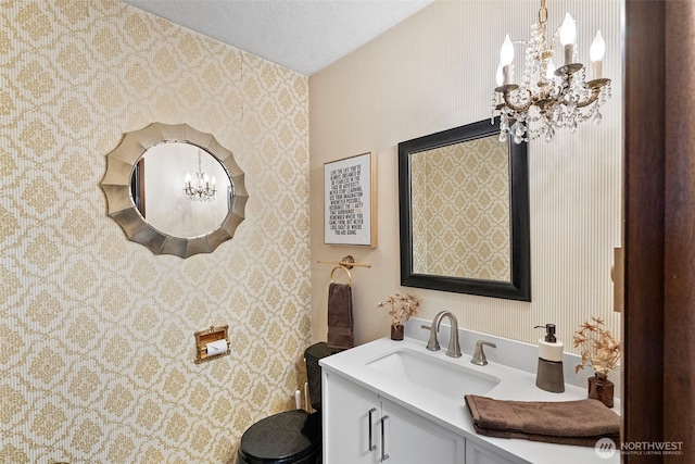 152 E Park Ln, Port Angeles, WA 98362 - bathroom featuring a chandelier, vanity, wallpapered walls, and a textured ceiling