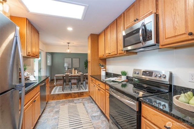 8618 94th St SW, Lakewood, WA 98498 - kitchen with stainless steel appliances, dark stone counters, brown cabinetry, and recessed lighting