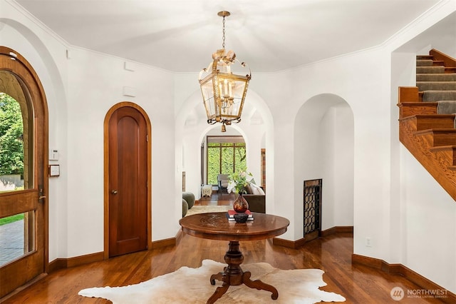 3103 Mount Rainier Dr S, Seattle, WA 98144 - entrance foyer with arched walkways, wood finished floors, stairs, crown molding, and a chandelier