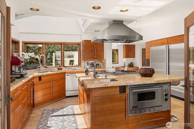 3103 Mount Rainier Dr S, Seattle, WA 98144 - kitchen featuring island exhaust hood, stainless steel appliances, brown cabinetry, light stone countertops, and a kitchen island with sink