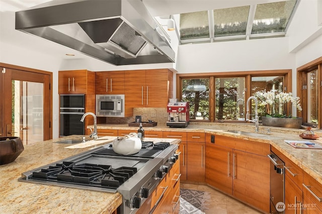 3103 Mount Rainier Dr S, Seattle, WA 98144 - kitchen with wall chimney exhaust hood, brown cabinetry, appliances with stainless steel finishes, backsplash, and light stone countertops