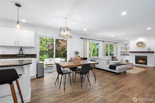 9220 NE 195th St, Bothell, WA 98011 - dining area featuring recessed lighting, dark wood-type flooring, a brick fireplace, a chandelier, and built in features