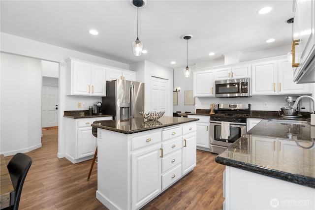 9220 NE 195th St, Bothell, WA 98011 - kitchen featuring appliances with stainless steel finishes, a kitchen island, dark wood finished floors, white cabinets, and hanging light fixtures