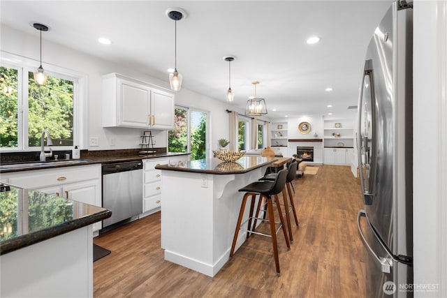 9220 NE 195th St, Bothell, WA 98011 - kitchen with appliances with stainless steel finishes, open floor plan, white cabinets, a kitchen breakfast bar, and recessed lighting