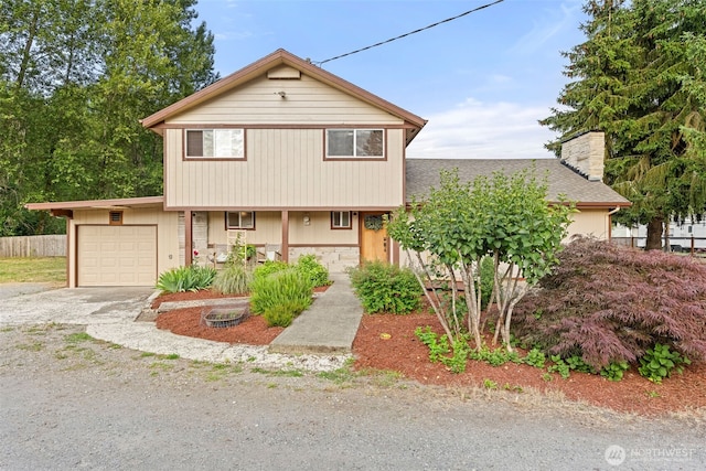 407 Leber St NE, Orting, WA 98360 - view of front of property featuring a chimney, covered porch, gravel driveway, a garage, and stone siding