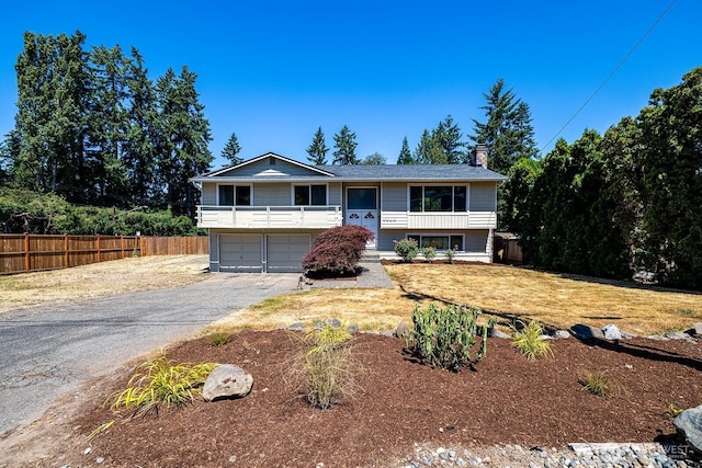6808 NE 165th St, Kenmore, WA 98028 - bi-level home featuring asphalt driveway, a garage, a chimney, and covered porch