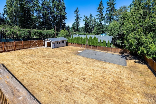 6808 NE 165th St, Kenmore, WA 98028 - fenced backyard with a patio area, an outdoor structure, and view of scattered trees
