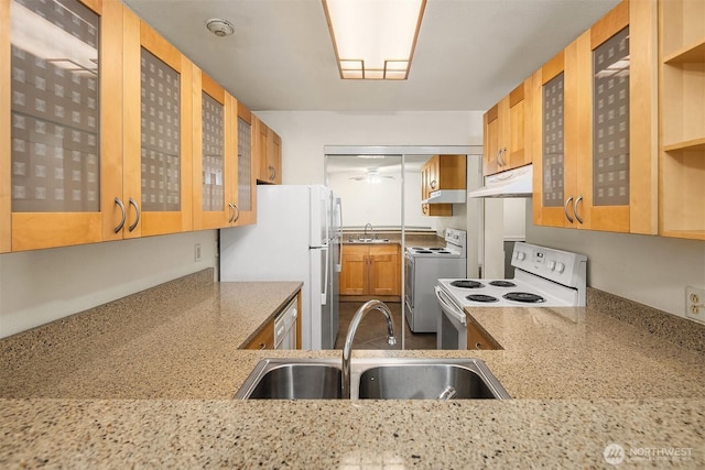 2506 S 317th St Unit 103, Federal Way, WA 98003 - kitchen featuring white appliances, under cabinet range hood, light stone countertops, and glass insert cabinets