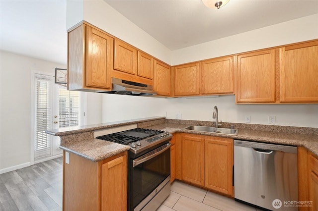 1255 NE 152nd St Unit 3, Shoreline, WA 98155 - kitchen with appliances with stainless steel finishes, under cabinet range hood, a peninsula, and light wood-type flooring