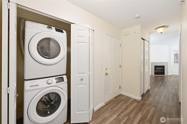 1255 NE 152nd St Unit 3, Shoreline, WA 98155 - washroom with stacked washing machine and dryer, wood finished floors, and a tiled fireplace