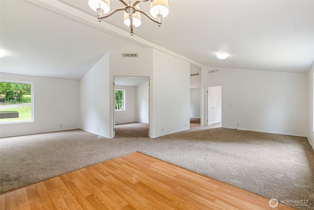 370 Van Wyck Rd, Bellingham, WA 98226 - empty room with vaulted ceiling, carpet flooring, a chandelier, and wood finished floors