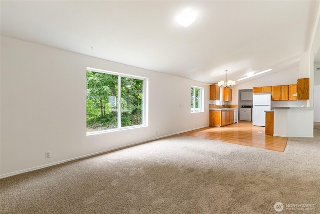370 Van Wyck Rd, Bellingham, WA 98226 - unfurnished living room with light colored carpet, a chandelier, and vaulted ceiling