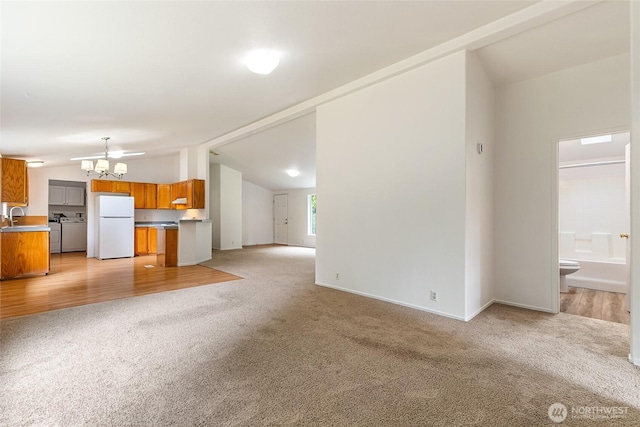 370 Van Wyck Rd, Bellingham, WA 98226 - unfurnished living room with vaulted ceiling, light carpet, and a chandelier
