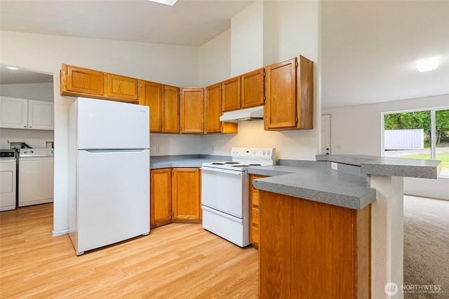 370 Van Wyck Rd, Bellingham, WA 98226 - kitchen with white appliances, washing machine and clothes dryer, under cabinet range hood, a peninsula, and light wood-style flooring