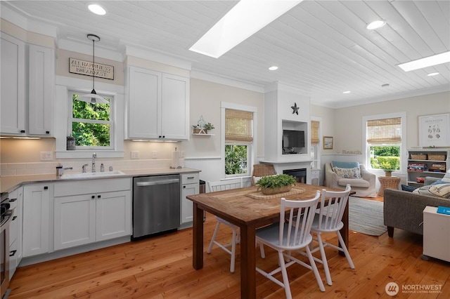17 Beach Cabin Ln, Pacific Beach, WA 98571 - kitchen featuring appliances with stainless steel finishes, open floor plan, a skylight, crown molding, and light wood finished floors