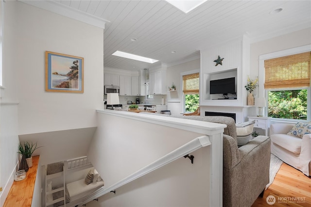 17 Beach Cabin Ln, Pacific Beach, WA 98571 - living room with light wood-style floors, healthy amount of natural light, wood ceiling, crown molding, and a fireplace