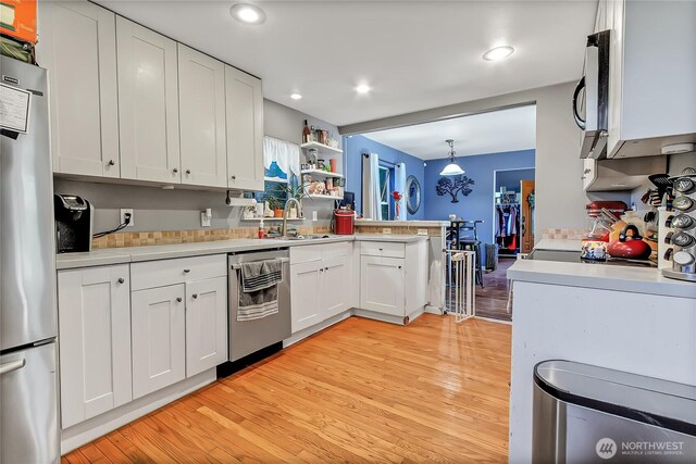 14812 SE 368th Pl, Auburn, WA 98092 - kitchen with appliances with stainless steel finishes, light countertops, white cabinetry, light wood-type flooring, and a peninsula