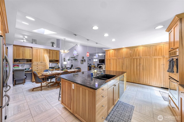 599 Loomis Trail Rd, Lynden, WA 98264 - kitchen with stainless steel appliances, a center island with sink, recessed lighting, dark stone counters, and a skylight