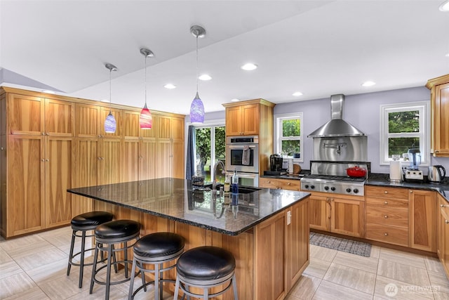 599 Loomis Trail Rd, Lynden, WA 98264 - kitchen featuring wall chimney exhaust hood, stainless steel appliances, a center island with sink, a kitchen breakfast bar, and decorative light fixtures