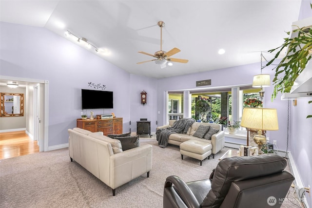 599 Loomis Trail Rd, Lynden, WA 98264 - living room featuring vaulted ceiling, light carpet, ceiling fan, a baseboard heating unit, and a wood stove