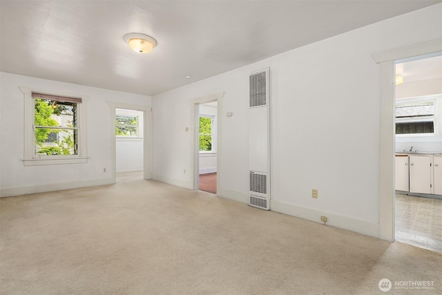 9559 College Way N, Seattle, WA 98103 - unfurnished room with a heating unit, healthy amount of natural light, and light colored carpet