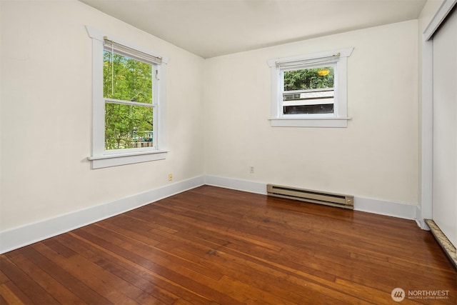 9559 College Way N, Seattle, WA 98103 - empty room featuring a baseboard radiator, healthy amount of natural light, and hardwood / wood-style flooring