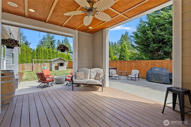 218 Lilly Ln, Mount Vernon, WA 98274 - deck featuring a grill, a shed, a fenced backyard, an outdoor living space with a fire pit, and a ceiling fan
