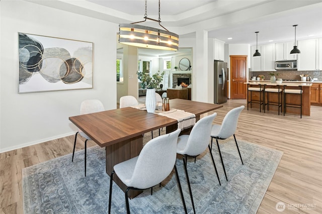 3419 NE Meadow Way, Issaquah, WA 98029 - dining space featuring recessed lighting, light wood-style floors, and a stone fireplace