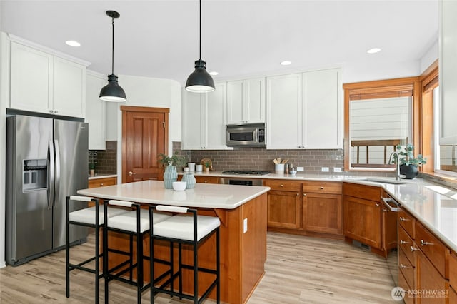 3419 NE Meadow Way, Issaquah, WA 98029 - kitchen featuring stainless steel appliances, light wood-style floors, tasteful backsplash, and recessed lighting