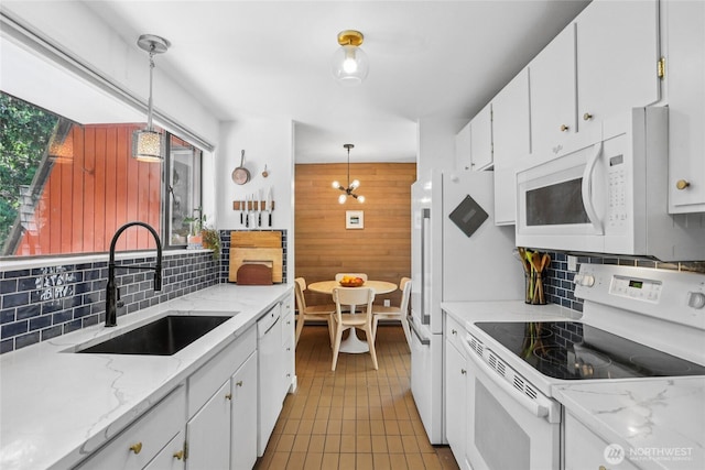 10765 Burke Ave N Unit 14, Seattle, WA 98133 - kitchen with white appliances, tasteful backsplash, white cabinets, wood walls, and pendant lighting
