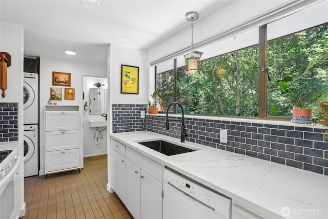 10765 Burke Ave N Unit 14, Seattle, WA 98133 - kitchen with white dishwasher, estacked washer and dryer, decorative backsplash, white cabinets, and recessed lighting
