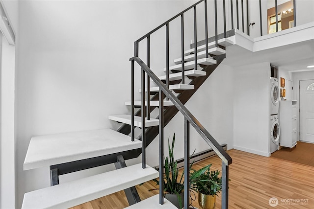10765 Burke Ave N Unit 14, Seattle, WA 98133 - stairway featuring stacked washer / dryer, wood finished floors, and a high ceiling