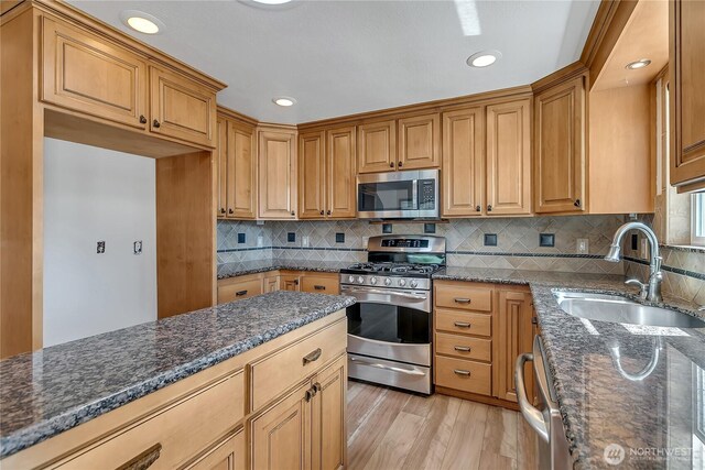 622 119th Ave E, Edgewood, WA 98372 - kitchen with appliances with stainless steel finishes, dark stone countertops, light wood-style flooring, decorative backsplash, and recessed lighting