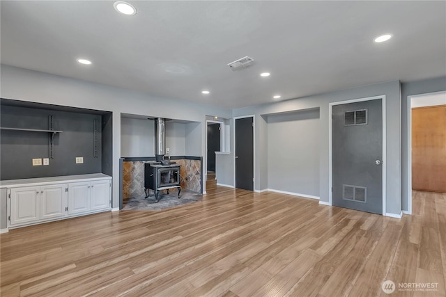 622 119th Ave E, Edgewood, WA 98372 - unfurnished living room featuring light wood-type flooring, a wood stove, and recessed lighting