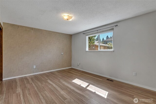 622 119th Ave E, Edgewood, WA 98372 - empty room featuring wood finished floors and a textured ceiling