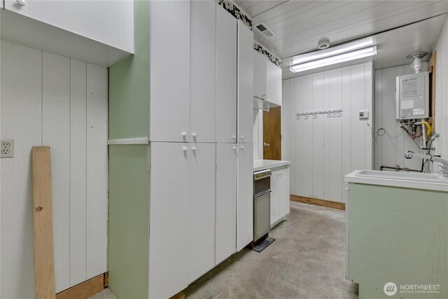 622 119th Ave E, Edgewood, WA 98372 - kitchen with water heater, concrete flooring, white cabinetry, and light countertops