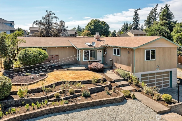 622 119th Ave E, Edgewood, WA 98372 - view of front facade featuring an attached garage, roof with shingles, a chimney, and driveway