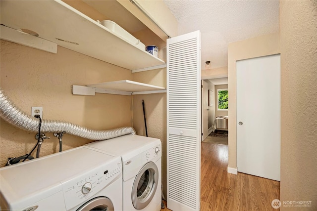 15749 NE 18th St Unit B5, Bellevue, WA 98008 - laundry area featuring washer and clothes dryer, light wood-style floors, a textured wall, and a wall mounted AC