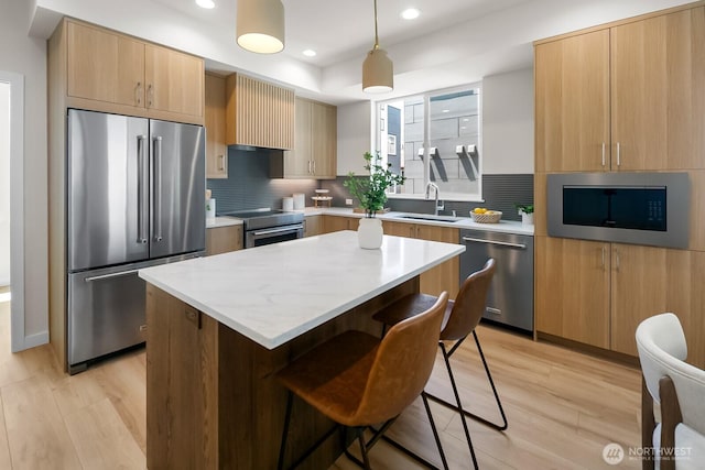 1746A NW 62nd St, Seattle, WA 98107 - kitchen featuring stainless steel appliances, light wood-style floors, a kitchen breakfast bar, recessed lighting, and tasteful backsplash