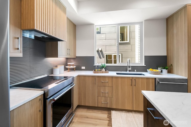 1746A NW 62nd St, Seattle, WA 98107 - kitchen with stainless steel appliances, light wood-style floors, wall chimney range hood, tasteful backsplash, and light stone countertops