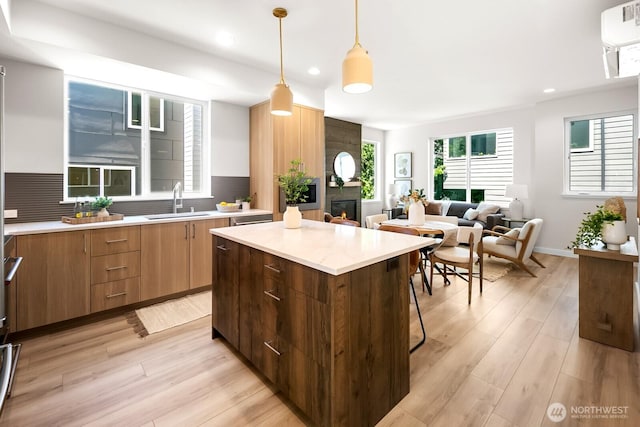1746A NW 62nd St, Seattle, WA 98107 - kitchen featuring a kitchen island, modern cabinets, a fireplace, light wood-style floors, and recessed lighting
