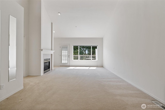 22532 43rd Ave S Unit 19-2, Kent, WA 98032 - unfurnished living room featuring light carpet, a tile fireplace, and lofted ceiling