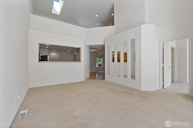 22532 43rd Ave S Unit 19-2, Kent, WA 98032 - unfurnished living room with carpet, a skylight, high vaulted ceiling, and recessed lighting