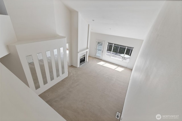 22532 43rd Ave S Unit 19-2, Kent, WA 98032 - unfurnished living room featuring carpet floors, heating unit, a fireplace, and a high ceiling