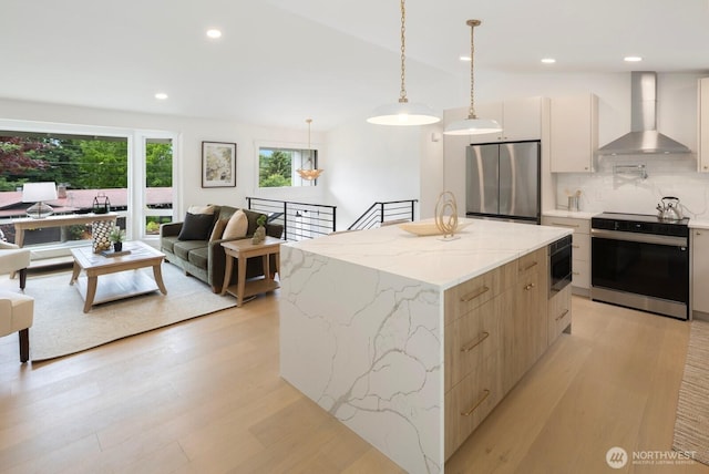 7502 117th Ave NE, Kirkland, WA 98033 - kitchen featuring stainless steel appliances, wall chimney range hood, modern cabinets, light wood-style floors, and recessed lighting