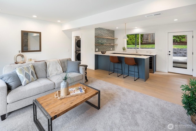 7502 117th Ave NE, Kirkland, WA 98033 - living area with stacked washer and clothes dryer, recessed lighting, light wood-style flooring, and beverage cooler