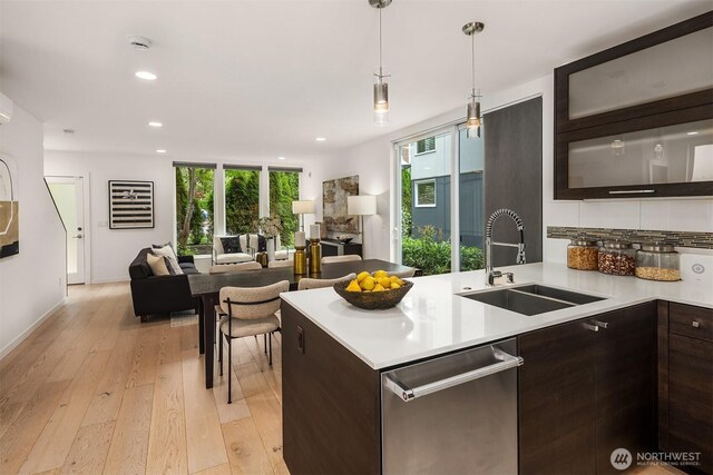909 29th Ave S, Seattle, WA 98144 - kitchen featuring dark brown cabinets, stainless steel dishwasher, light countertops, light wood-style flooring, and open floor plan